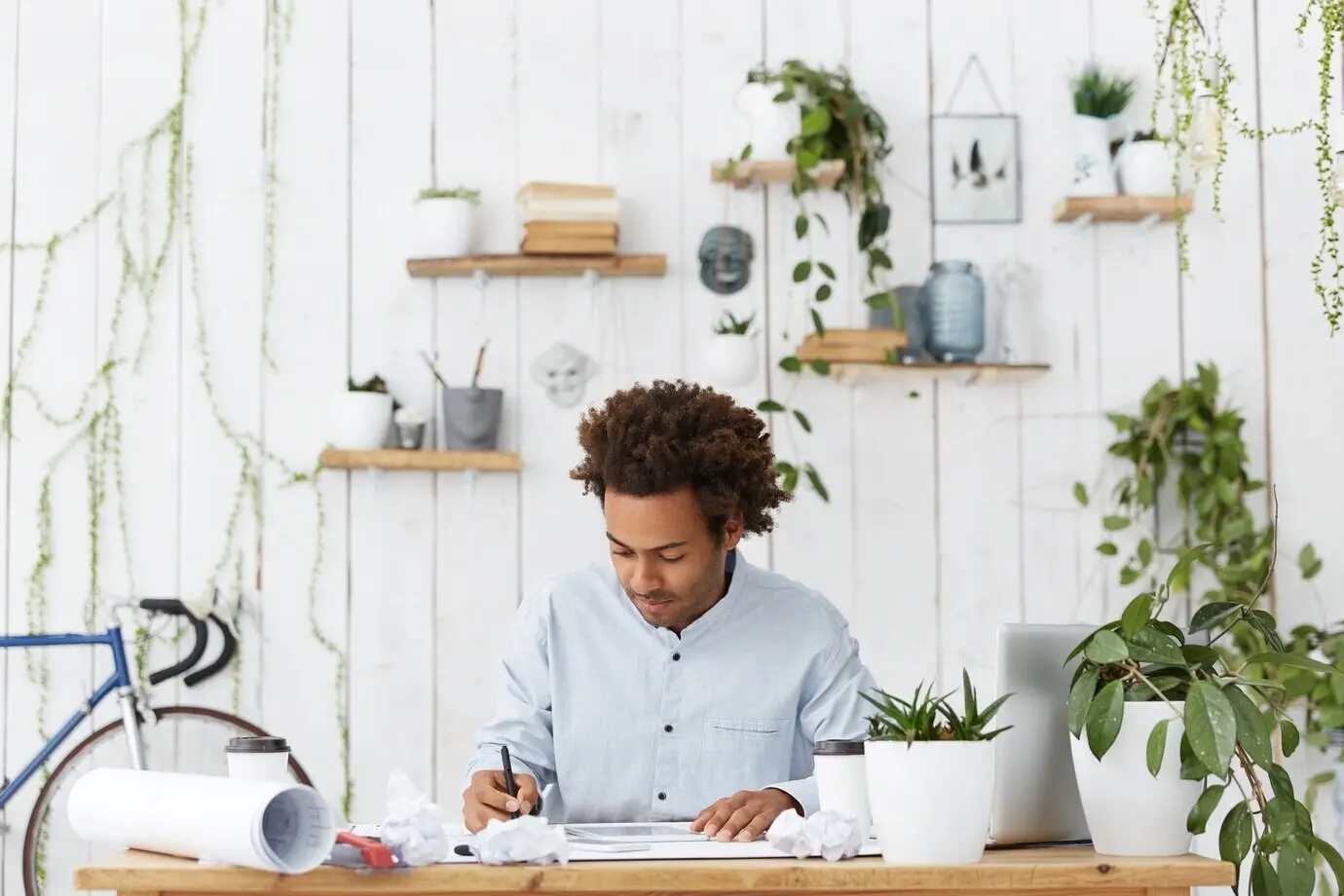 Eine attraktive, dunkelhäutige Architektin oder ein attraktiver, dunkelhäutiger Architekt in blauem Hemd fühlt sich glücklich und aufgeregt.
